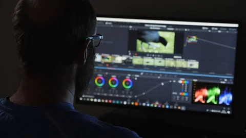 Man with beard working late at night editing and colour grading a film Stock Footage 100951184