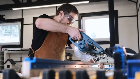 A man with a beard works in his workshop. Profession carpenter. A man works with Stock Footage 113994184