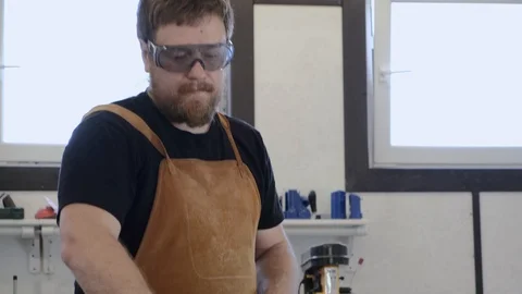 A man with a beard works in his workshop. Profession carpenter. A man works with Stock Footage 113994463