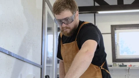 A man with a beard works in his workshop. Profession carpenter. A man works with Stock Footage 113994721