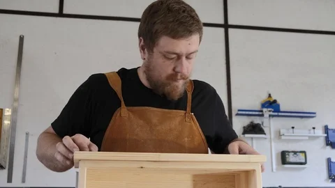 A man with a beard works in his workshop. Profession carpenter. A man works with Stock Footage 113995194