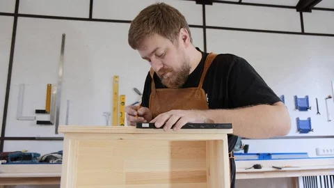 A man with a beard works in his workshop. Profession carpenter. A man works with Stock Footage 113995795