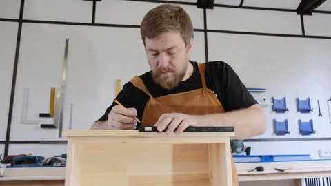 A man with a beard works in his workshop. Profession carpenter. A man works with Stock Footage 113995990