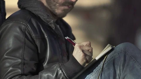 Man with beard is writing in his journal Stock Footage 71938481