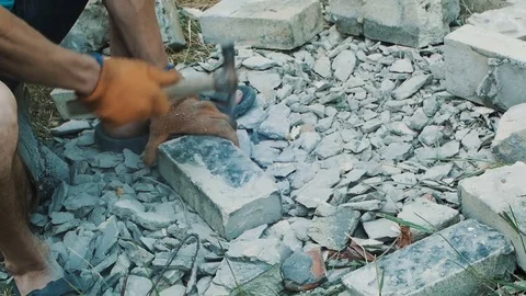 Man beats the bricks with a hammer Stock Footage 83321922