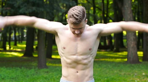 Man with a beautiful body, do exercises in the park Vídeos de archivo 64915975