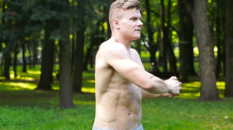 Man with a beautiful body, do exercises in the park Vídeo Stock 64916166