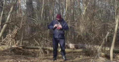 A man in a beautiful pine forest takes pictures with an old film camera Stock-Footage 166439295