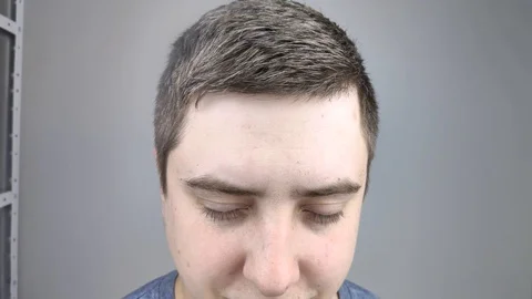 А man in a beauty salon is sprayed with varnish on his hair. The concept of male Video stock 126407415