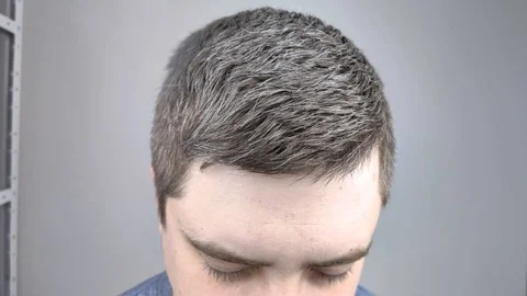 А man in a beauty salon is sprayed with varnish on his hair. The concept of male Stock Footage 126407431