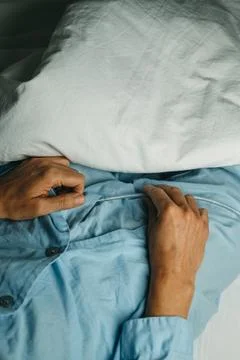 Man in bed handles his urinary catheterization Stock Photos