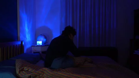 Man in bed has trouble falling asleep, insomnia and sleep problems lead to daily Stock Footage 326626277