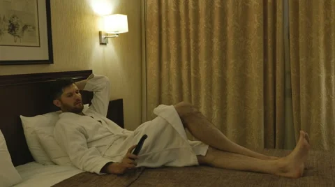 The man on the bed with the remote Stock-Footage 64768063