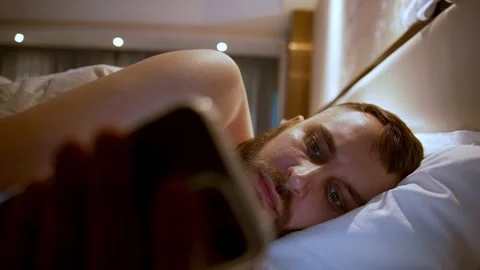 Man In Bed Scrolling Phone At Night Tech Addiction And Sleeplessness Stock Footage 323149726