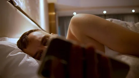 Man In Bed Scrolling Phone At Night Tech Addiction And Sleeplessness Stock Footage 324552339