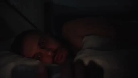 Man In Bed Scrolling Phone At Night Tech Addiction And Sleeplessness Video stock 328620852