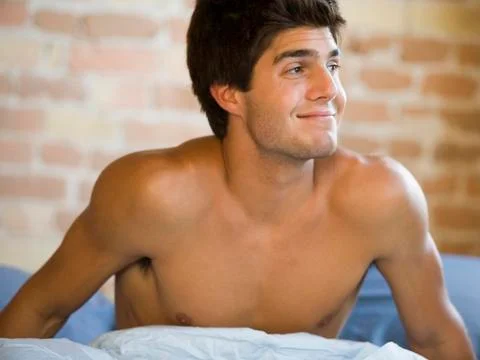 Man in bed stretching Stock Photos