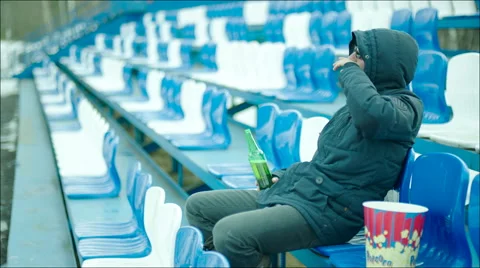 Man with beer bottle sitting at the stadium Vídeo Stock 63671069