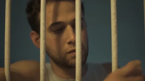 Man behind bars looking around with angry or frustrated face Stock Footage 108850027