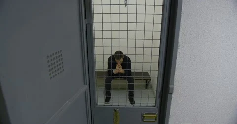 The man behind bars in a prison cell. The criminal Stock Footage 168989602