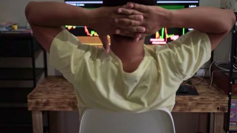 Man from behind clasping hands behind head, watching stock trading screens, Stock Footage 342748209