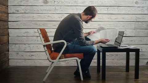 The man behind the computer looks at the documents Stock Footage 83473997