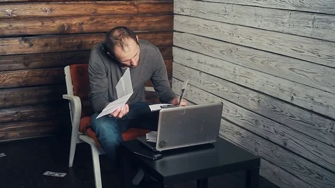 The man behind the computer looks at the documents Stock Footage 83478292