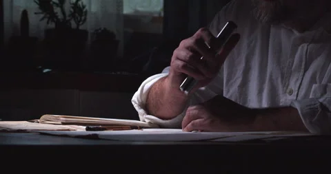 A man behind a desk full of documents begins dictating his notes into a Video stock 201303339
