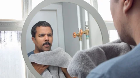 Man behind the mirror during his morning facial care routine Stock Footage 127041022