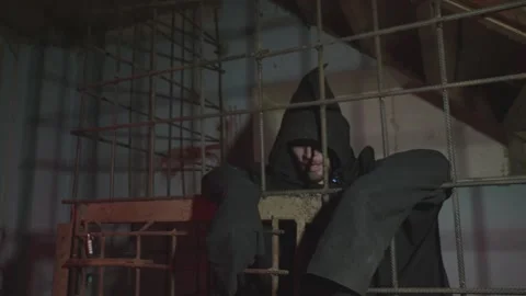 Man behind prison bars. The executioner person in jail. Halloween or horror Stock Footage 238661620