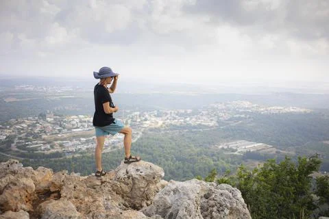 Man from behind standing on the edge of the mountain and watching a landscape Stock Photos