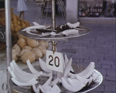 Man in beige suit buys a slice of coconut at Venetian market, Italy 1965 Stock Footage 132326306