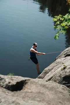 Man being belayed down a rock in Stockholm Stock Photos