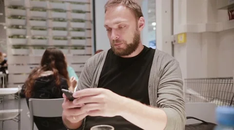 Man is being irritated. Man does not like his smartphone. Man holds a smartphone Stock Footage 67948170