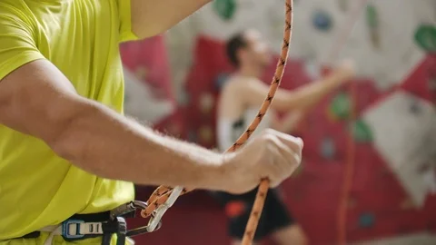 Man belaying another climber with rope. Top view of young athletic man belaying Vídeos de archivo 114266572