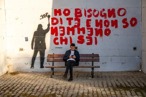 Man on Bench in Front of Graffiti 库存照片