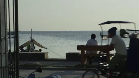 Man on bench looking out at boat dock in Philippines Stock Footage 76803240