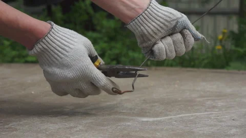 A man bends the wire with pliers. Hands in close up. Stock Footage 131258435