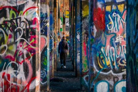 A Man In-Between A Row of Graffiti Covered Walls at Graffiti Pier Stock Photos