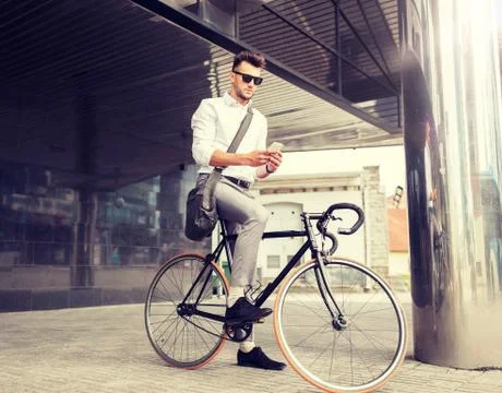 Man with bicycle and smartphone on city street Stock Photos