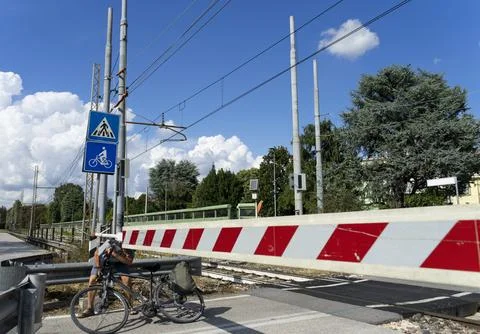 A man on a bicycle crosses the train tracks Stock Photos