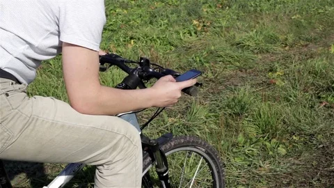 Man on bicycle looking on map in smartphone Stock Footage 74781009