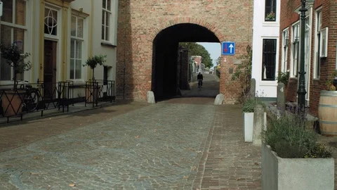 Man On Bicycle Passing By Under A Gate Stock Footage 127179886