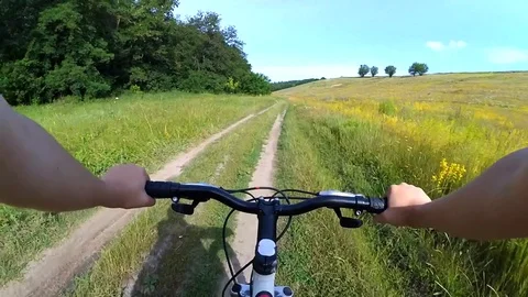 A man on a bicycle-ride is riding on a dirt road Stock Footage