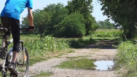 Man on a bicycle rides on a puddle Vídeo Stock 116479835