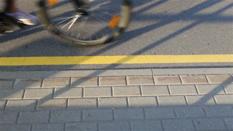 A man on a Bicycle sweeps past the camera. High angle, asphalt and dividing stri Stock Footage 112280883