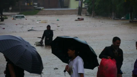 A man with bicycle walking in a muddy and polluted flood water Stock Footage 286012941