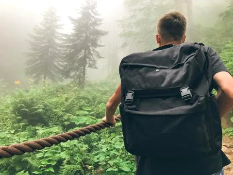 Man with a big back is walking in a forest in fog. Roza Khutor, Russia Stock Photos