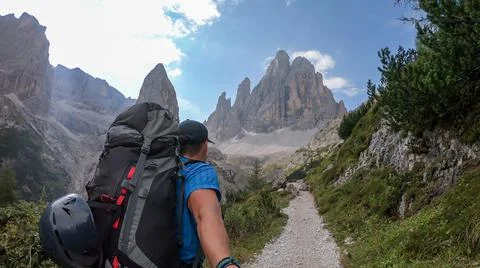 A man with big backpack taking a selfie while hiking along a narrow pathway Stock Photos