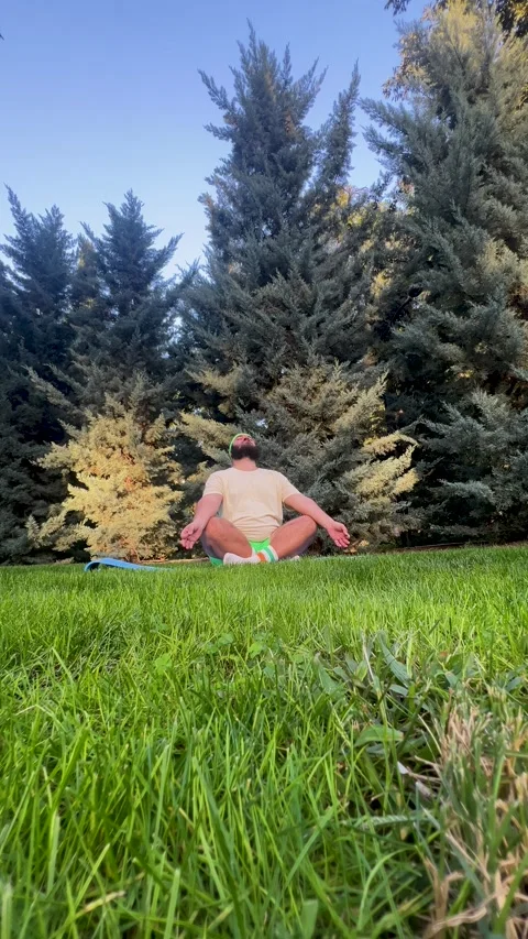 Man with big belly, headband on head, green shorts, sits easy Lotus pose Stock Footage 321852596